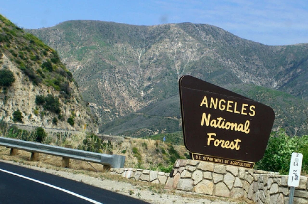 A sign on the side of a road that says " angeles national forest ".