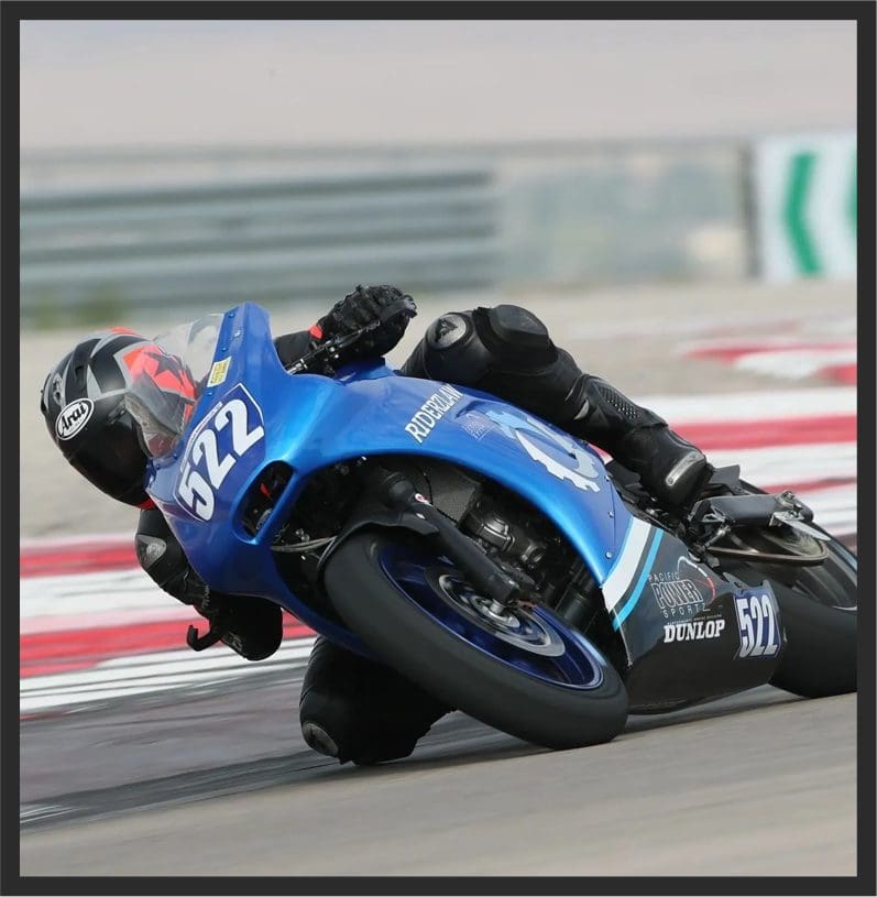 Blue racing motorcycle leaning sharply into turn