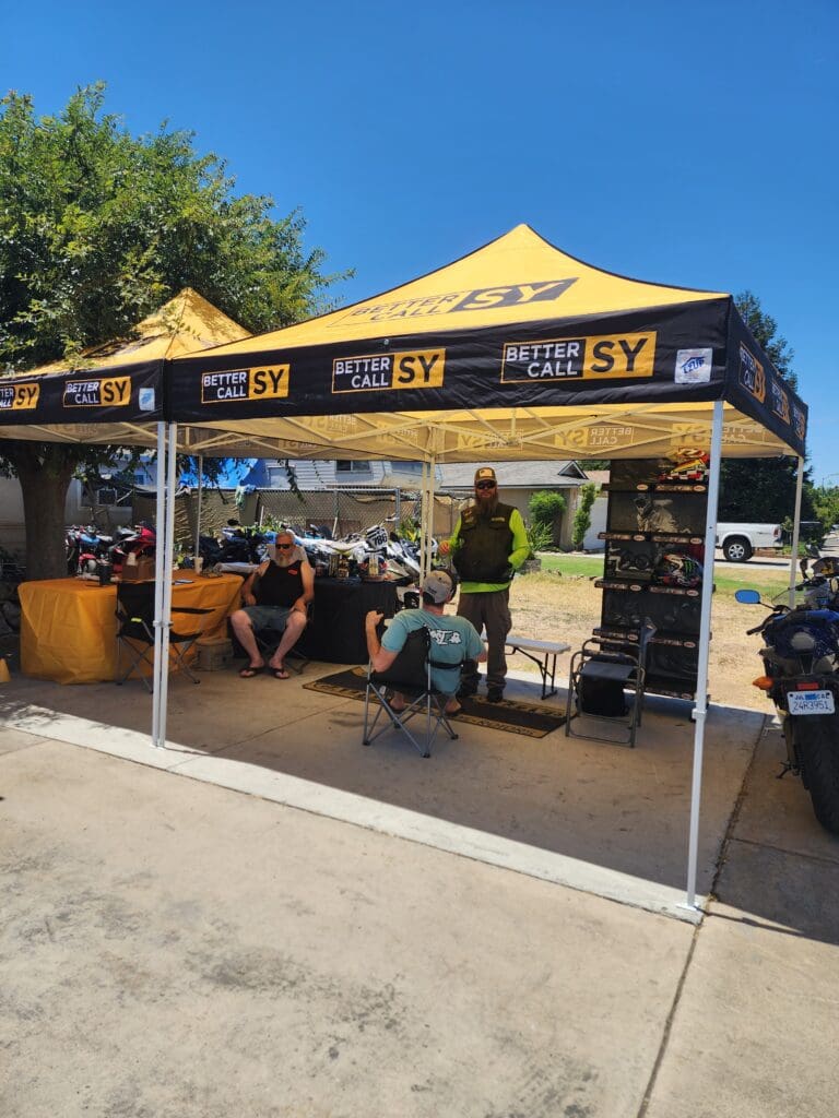 A group of people sitting under a yellow tent.