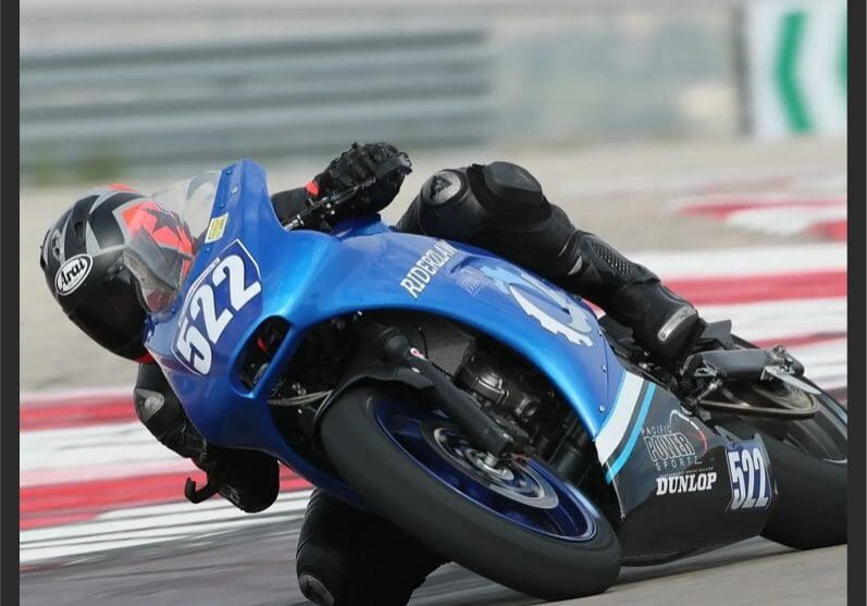 Blue racing motorcycle leaning sharply into turn